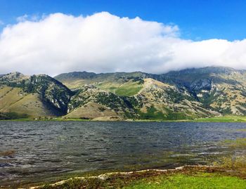 Scenic view of sea and mountains against sky