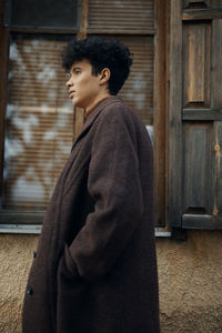 Young man standing against wall