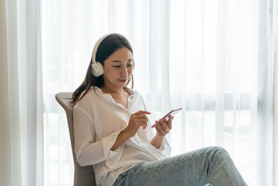 Young woman using mobile phone at home