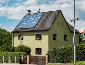 Electric solar panels on roof of nice modern house. rays of sun reflting in blue cells of panels