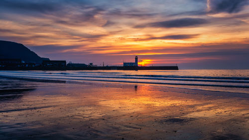 Scenic view of beach against sky during sunset