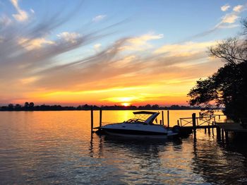 Boat in sea against sky during sunset