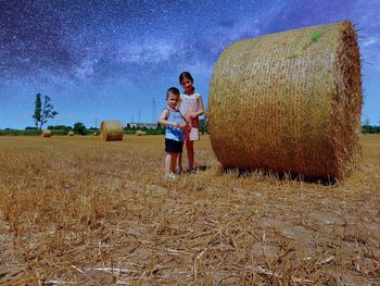 Full length of girl standing on field against sky