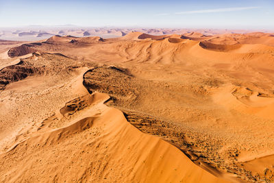 Sand dunes in desert against sky