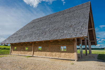 Barn on field against sky