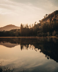 Scenic view of lake against sky at sunset