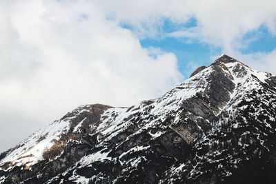 Low angle view of snowcapped mountains against sky