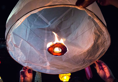 Close-up of hand holding illuminated lantern