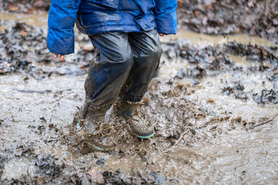 Low section of person jumping in mud