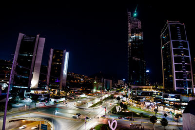 Illuminated city street and buildings at night