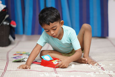 Side view of boy using laptop at home