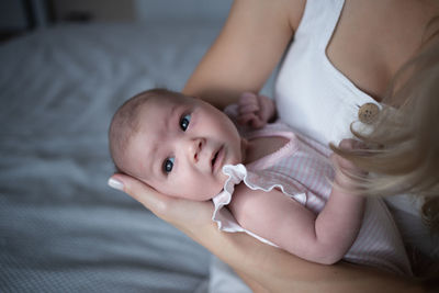 Close-up of mother carrying daughter at home