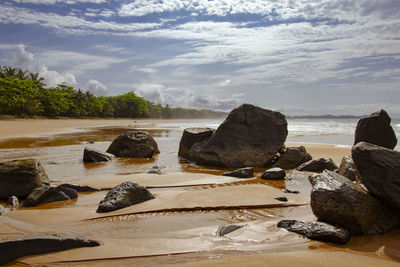 Rocks on beach against sky