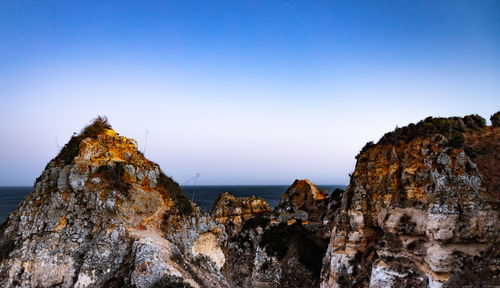 Panoramic view of rock formation against clear blue sky