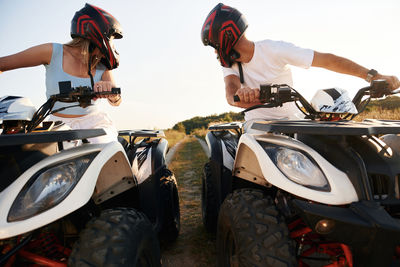 Rear view of man riding motor scooter on road