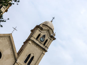 Low angle view of clock tower amidst buildings against sky