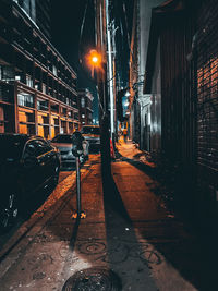 Street amidst illuminated buildings in city at night