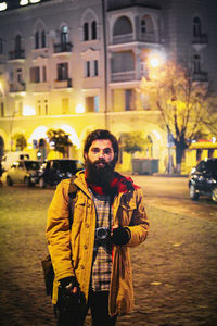 Portrait of young man standing on street at night