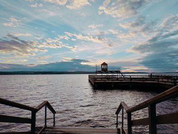 Pier on sea against sky during sunset