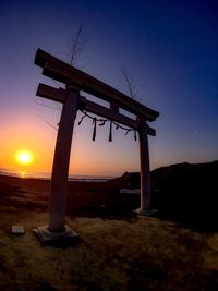 Silhouette built structure against sky during sunset