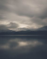 Scenic view of calm lake against cloudy sky