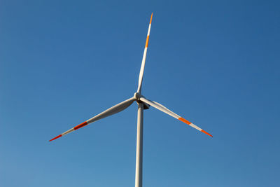 A wind turbine with a blue sky background