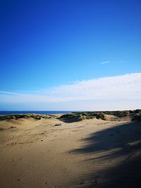 Scenic view of beach against blue sky