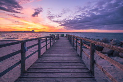 Pier over sea against sky during sunset