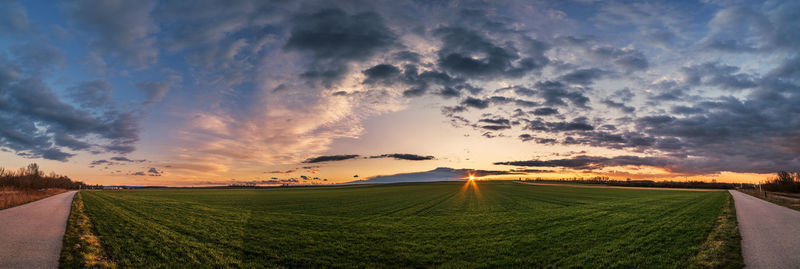 Scenic view of agricultural field against sky during sunset