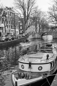 Sailboats moored on canal in city