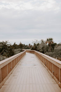 Footpath by swimming pool against sky