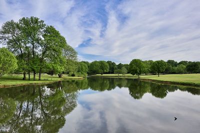 Scenic view of lake by trees against sky