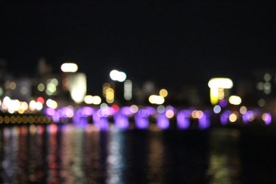 Defocused illuminated lights above river at night
