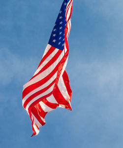 Low angle view of flag against blue sky