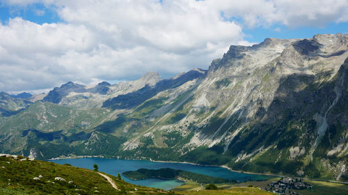 Scenic view of lake by mountains against sky