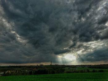 Scenic view of field against cloudy sky