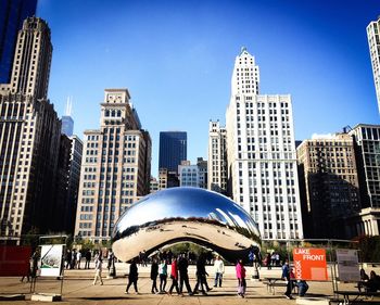 People at millennium park against cityscape