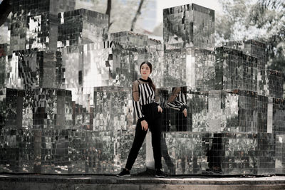 Full length of woman standing against glass structure
