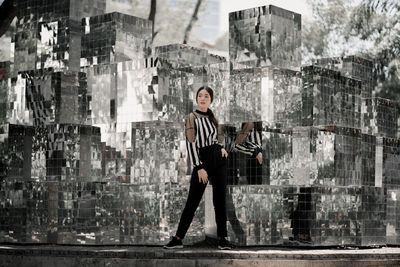 Portrait of woman standing against buildings