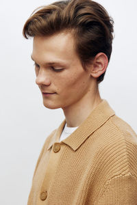 Portrait of young man standing against white background