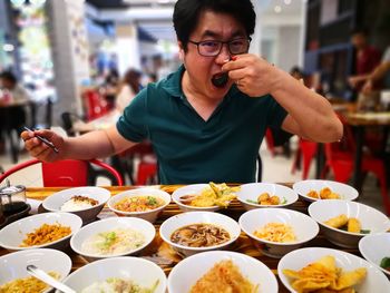 Midsection of man holding ice cream in restaurant