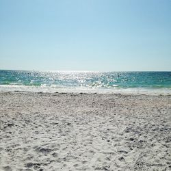 Scenic view of beach against clear blue sky