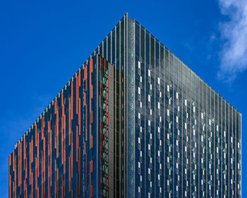 Low angle view of modern building against blue sky