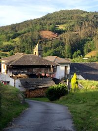 Houses by mountain against sky