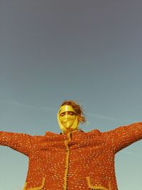 Woman face wrapped with ribbons against sky