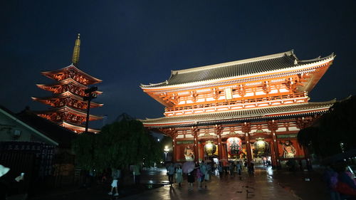 People on illuminated building at night