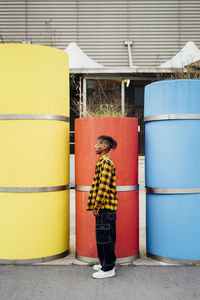 Young man standing in front of red concrete pipe