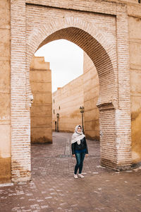 Full length of woman standing at historical building