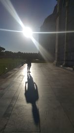 Man walking on street against sun