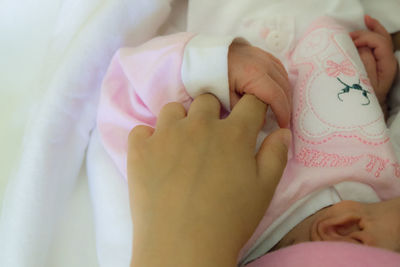 Midsection of mother with baby on bed